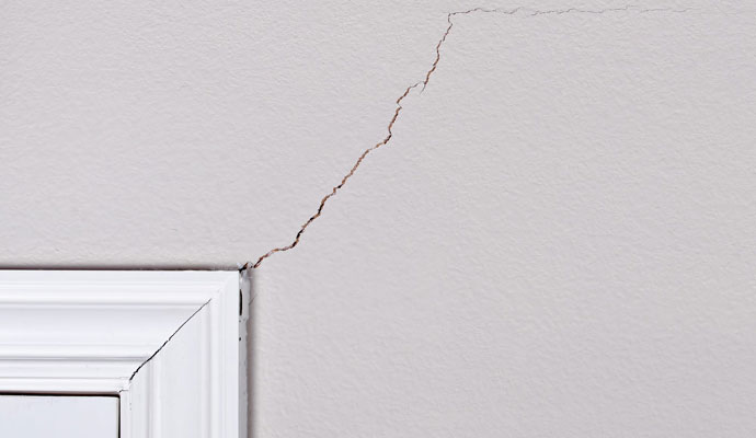 Diagonal structural settling crack above interior door frame