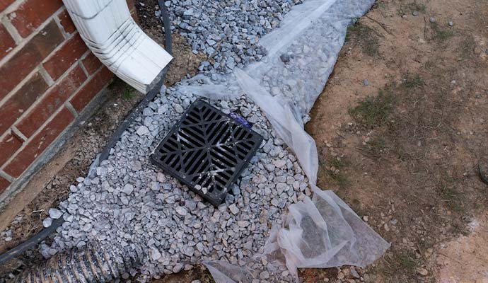 Outdoor drainage system with downspout connected to catch basin