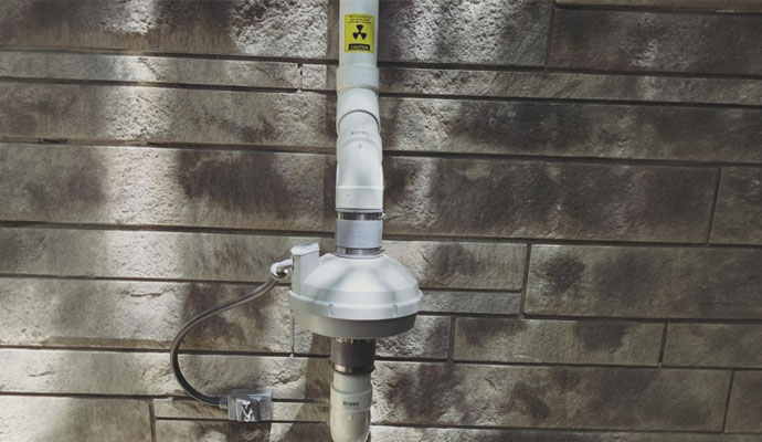 Radon reduction system exterior wall mount
