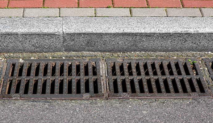 Street curb with metal storm drain grates