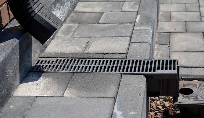 Trench drain with grated cover connected to downspout