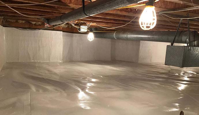 White moisture vapor barrier lining the floor and walls of a crawl space